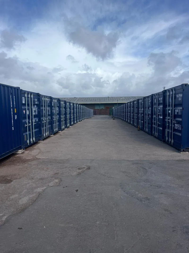 Industrial yard with shipping containers and heavy equipment