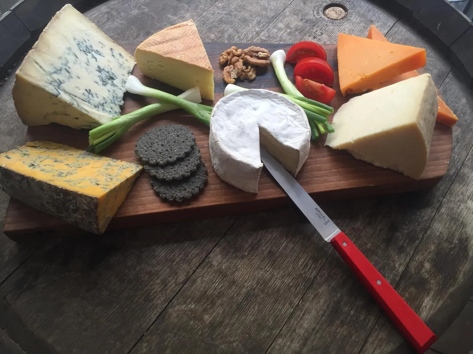 Artisanal British cheese board featuring various premium cheeses with crackers and accompaniments
