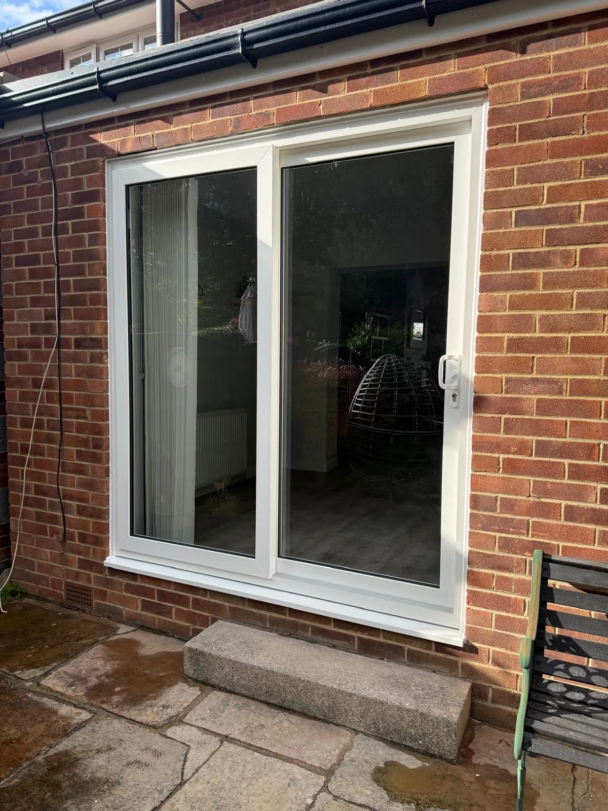 White uPVC sliding patio doors fitted to a red brick house.