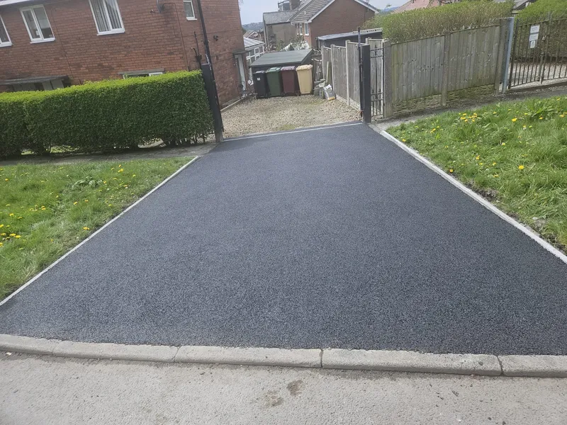 Fresh tarmac driveway with concrete kerb edging