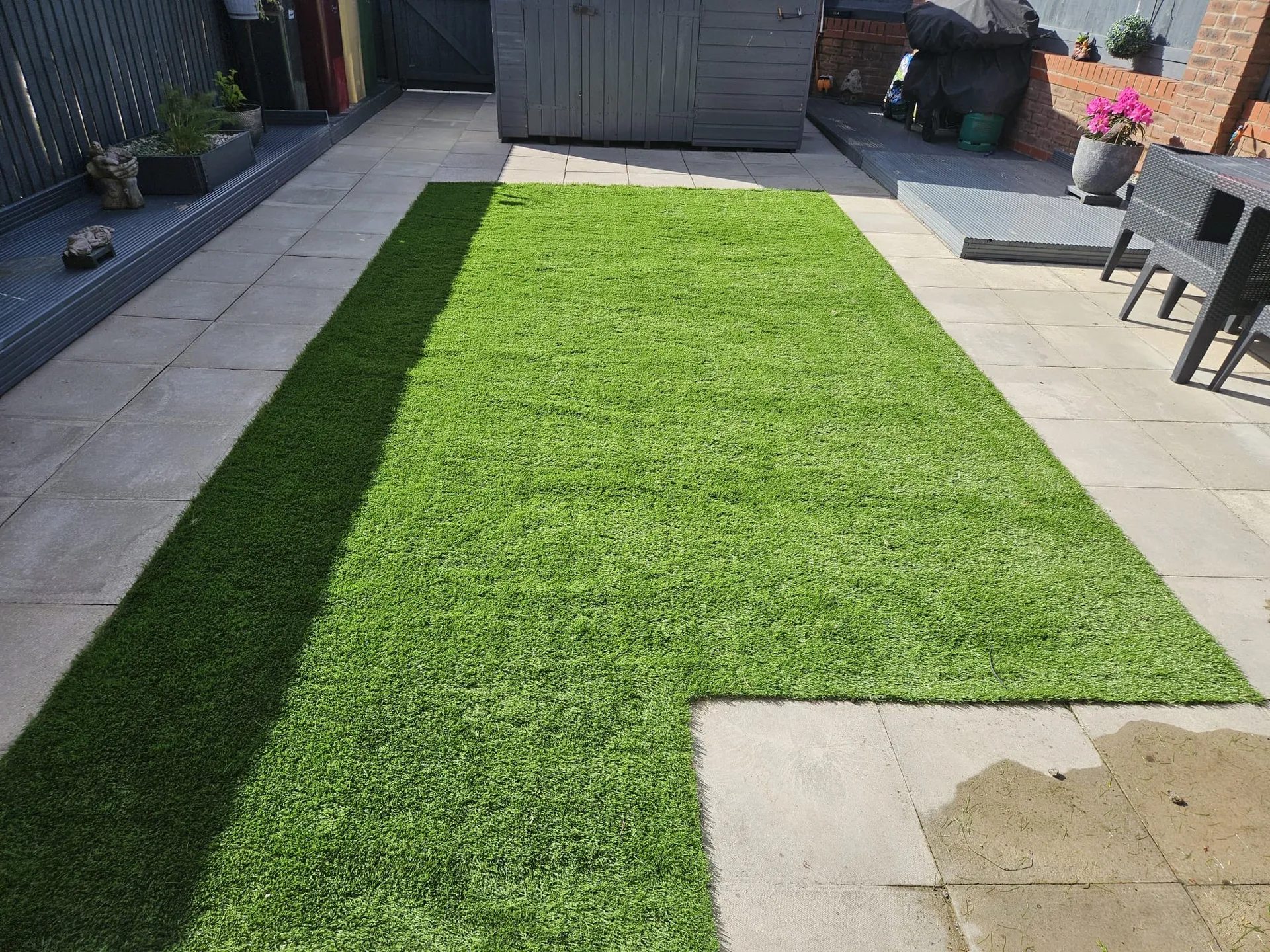 Premium artificial grass installation with integrated paving