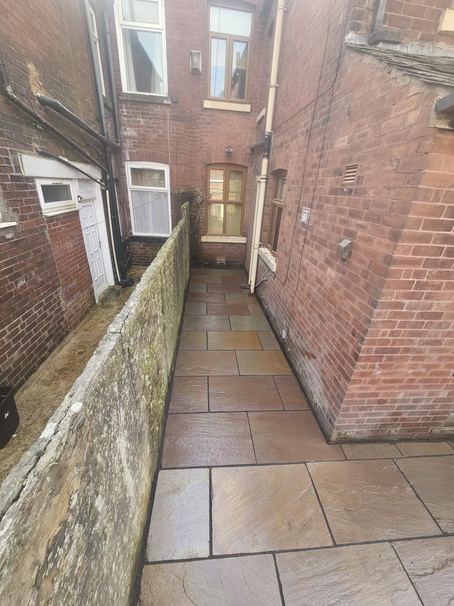 New Indian sandstone paving in a terraced back yard in Bolton by Barlow Landscapes