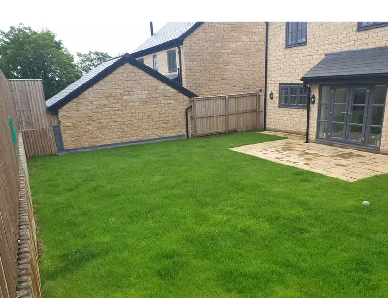 Natural garden design with fresh turf laying and stone patio area