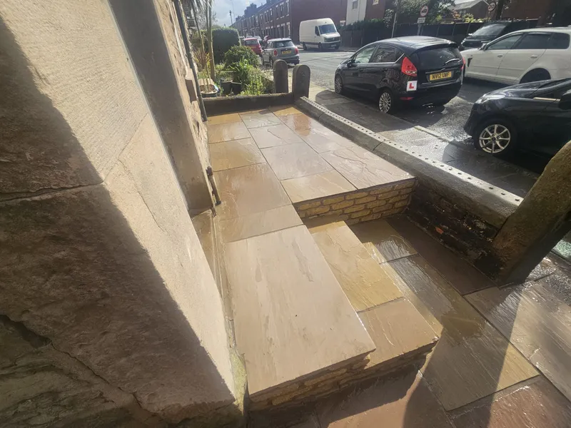 New Indian sandstone steps and paving at the front of a stone terraced house in Adlington