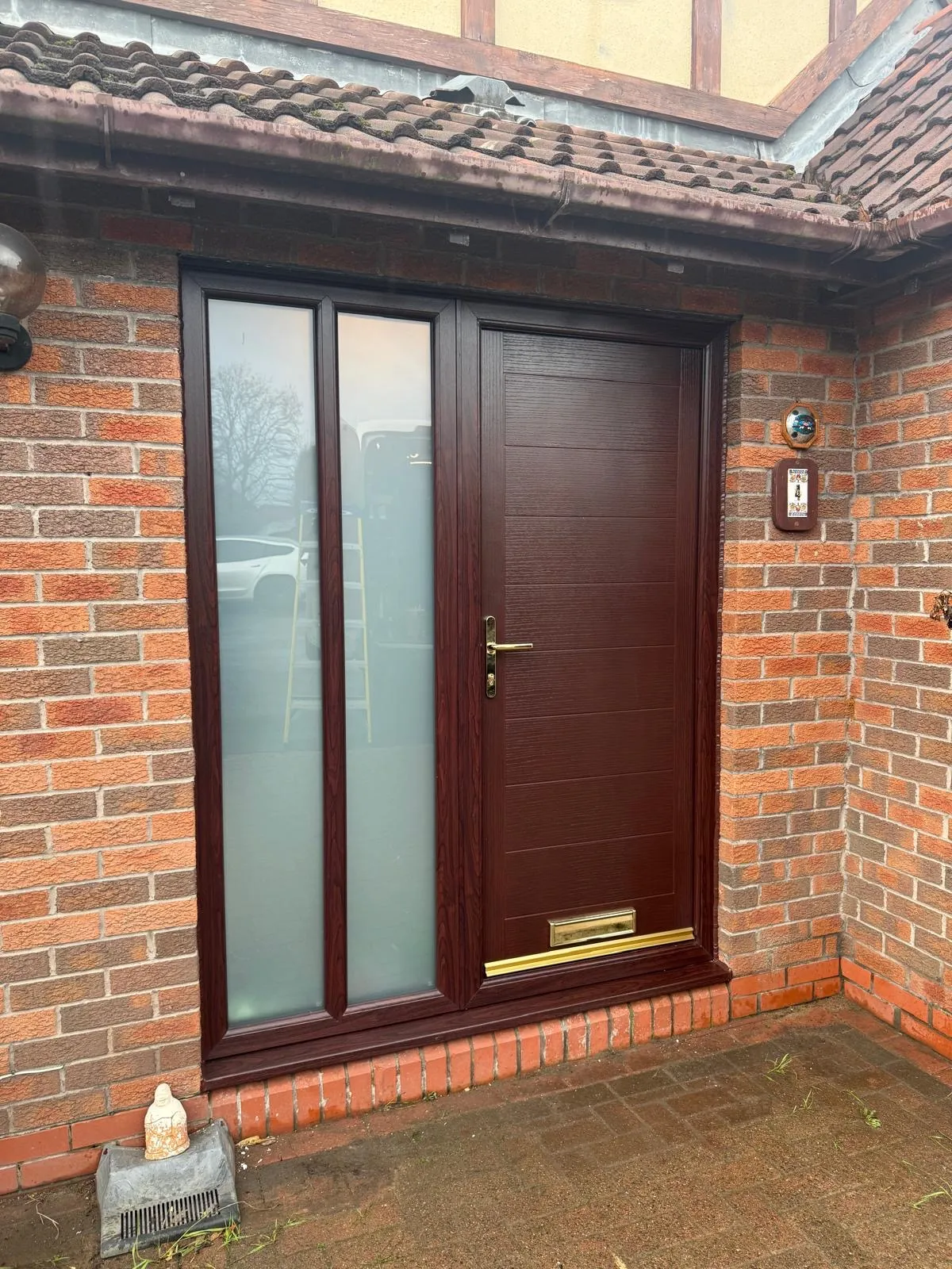 Rosewood composite front door with full-length frosted glass sidelight on a red brick home.